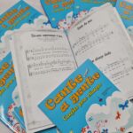 Edições do Cante com a gente dispostas formando um círculo, com uma dos livros abertos, mostrando as cifras das músicas e outro na parte inferior, com foco no título