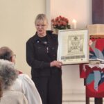 Presbitera representante do sínodo e comunidade Martin Luther entregando um quadro da Capela.
